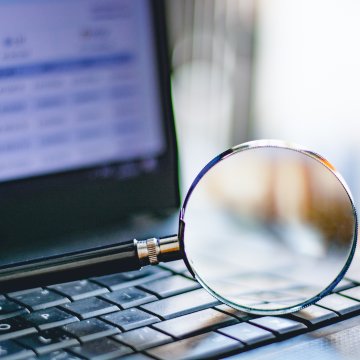 background check services truthfinder cost price laptop with magnifying glass on the keyboard